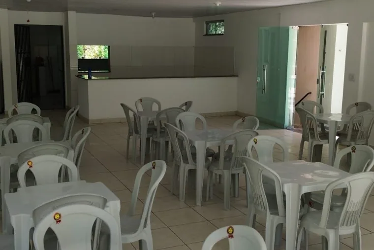 Área comum com mesas e cadeiras, em unidade de acolhimento da rede em Minas Gerais