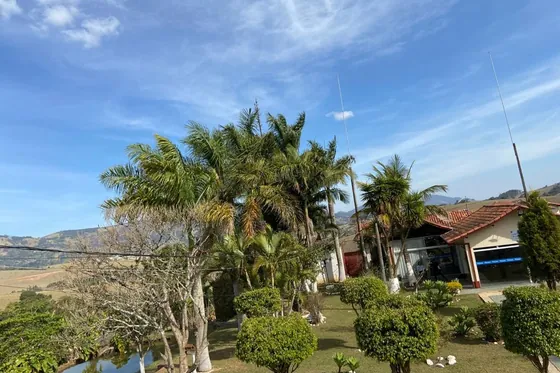 Clínica de reabilitação em Extrema - MG Jardim com árvores e casa ao fundo
