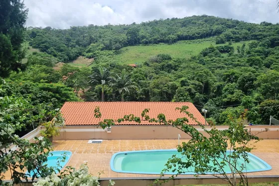 Clínica de reabilitação em Formiga - MG Piscina com vegetação e montanha ao fundo
