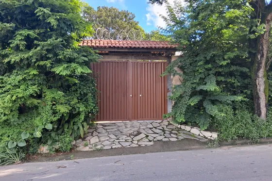 Entrada com portão e vegetação