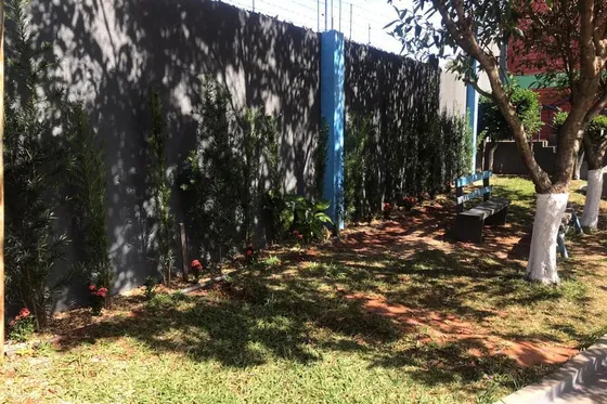 Jardim com bancos e parede verde