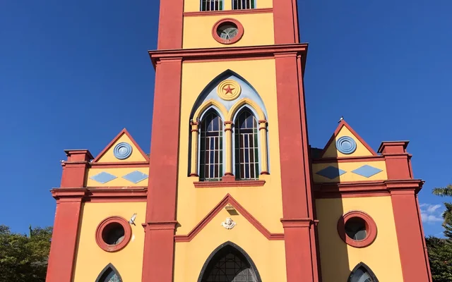 Igreja com torre e detalhes coloridos em Papagaios