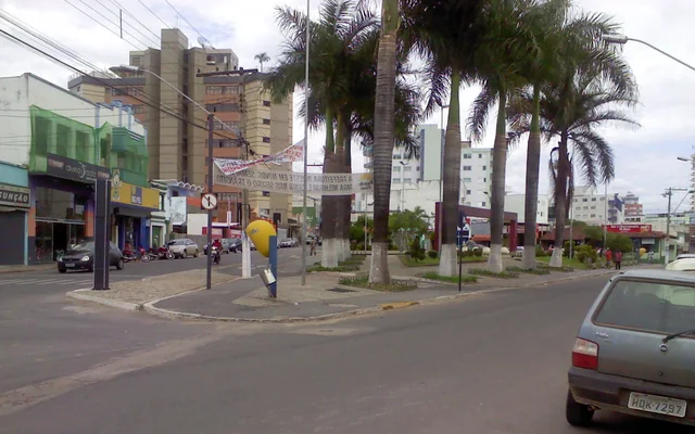 rua com árvores e comércio local em Pará de Minas
