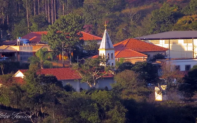 Igreja e casas em ambiente natural em Pitangui