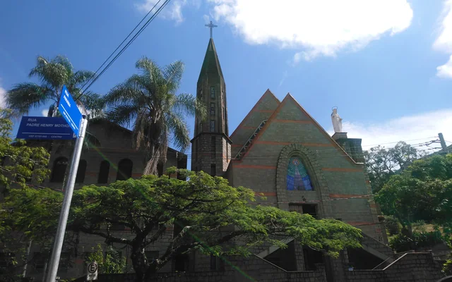Igreja com árvore e céu azul em Poços de Caldas
